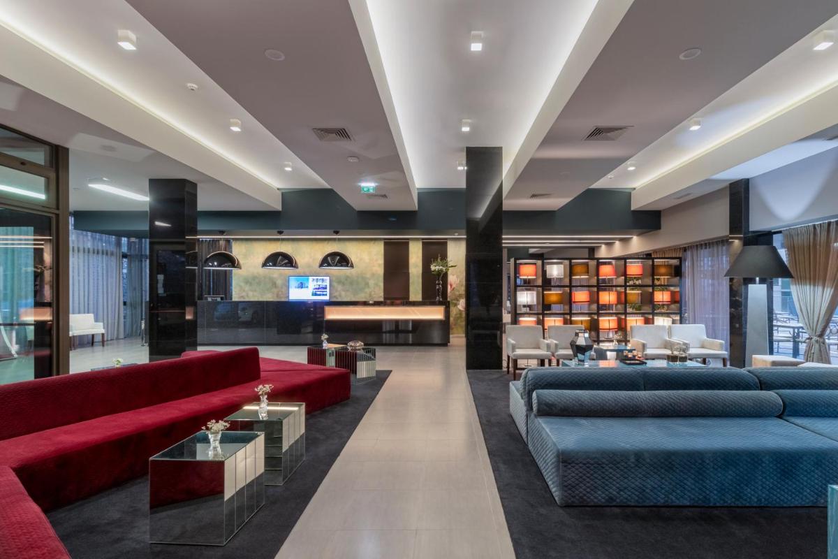 uma sala de estar com sofás vermelhos e um átrio em Enotel Magnólia no Funchal
