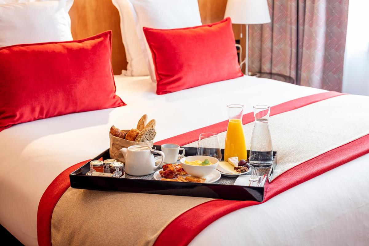 - un plateau de petit-déjeuner sur un lit dans l'établissement Le M & Spa Bordeaux Aéroport by Hôtels & Préférence, à Mérignac