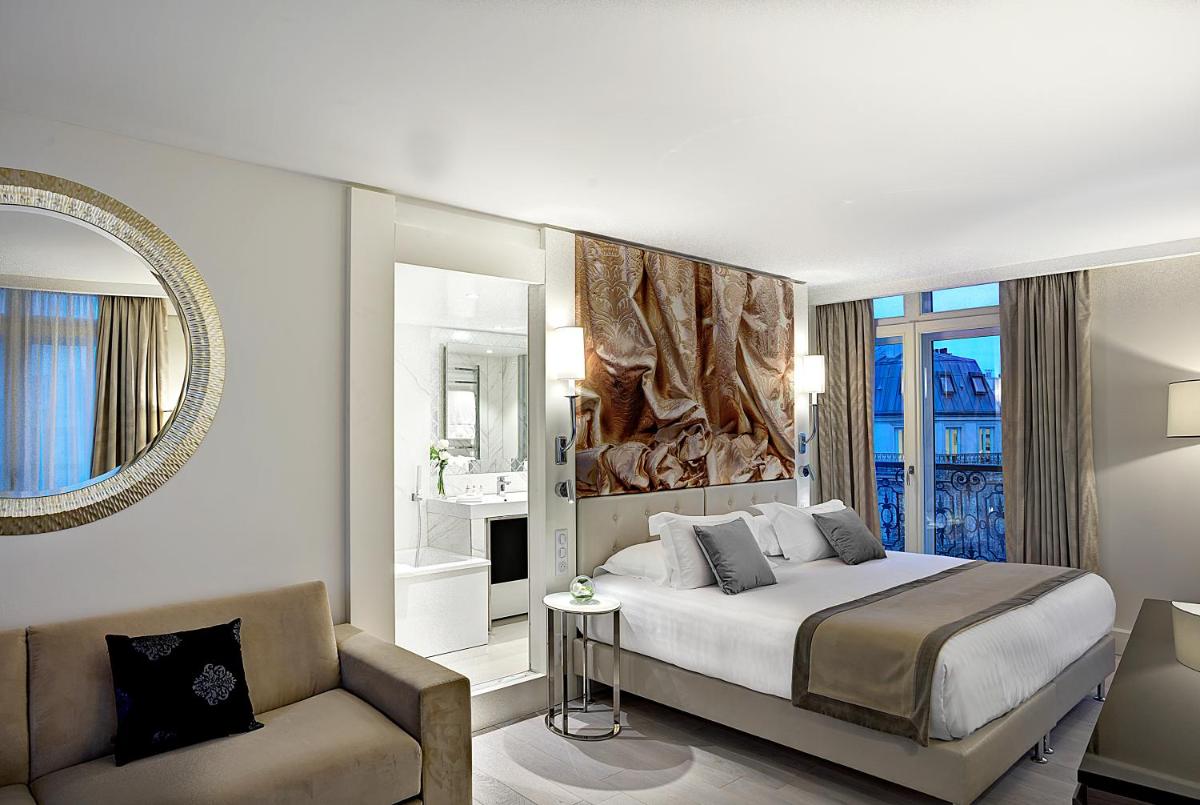 une chambre avec un lit, un canapé et un miroir dans l'établissement La Villa Haussmann, à Paris
