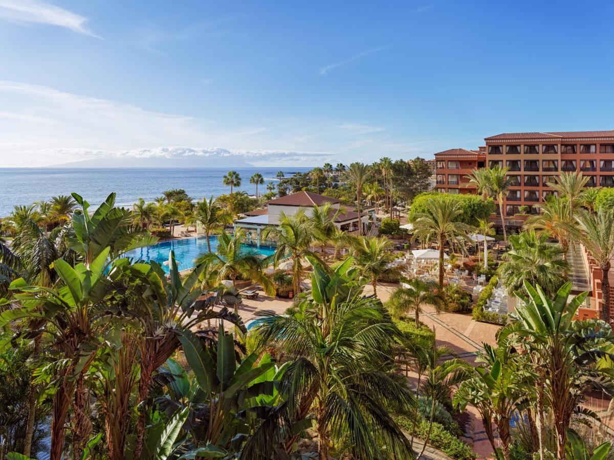 Una vista aérea de un resort con piscina y palmeras. en H10 Costa Adeje Palace, en Adeje