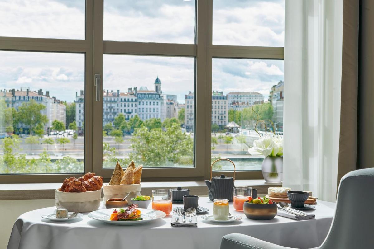 - une table avec de la nourriture et une vue sur la ville dans l'établissement InterContinental Lyon - Hotel Dieu by IHG, à Lyon