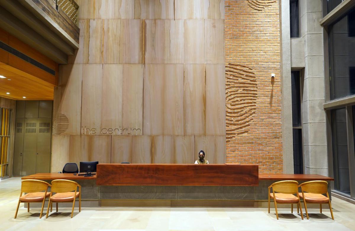 a reception desk in a building with chairs at The Centrum in Lucknow