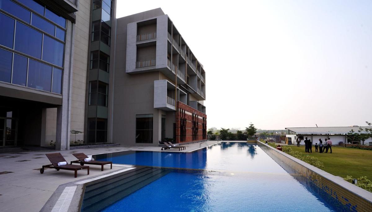 a swimming pool in front of a building at The Centrum in Lucknow