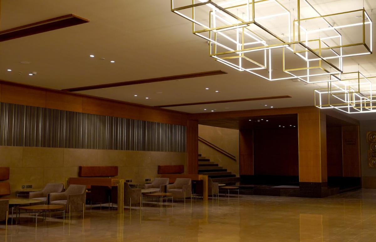 a lobby with tables and chairs in a building at The Centrum in Lucknow