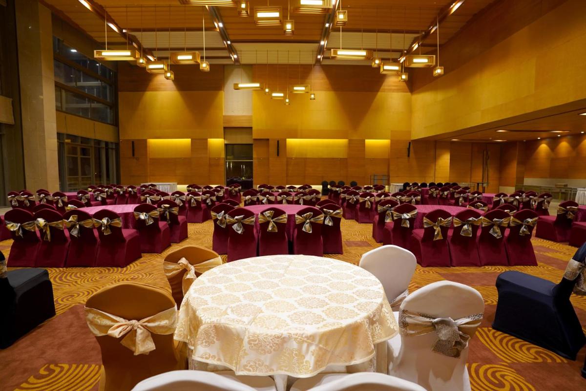 a banquet hall with a table and chairs in it at The Centrum in Lucknow