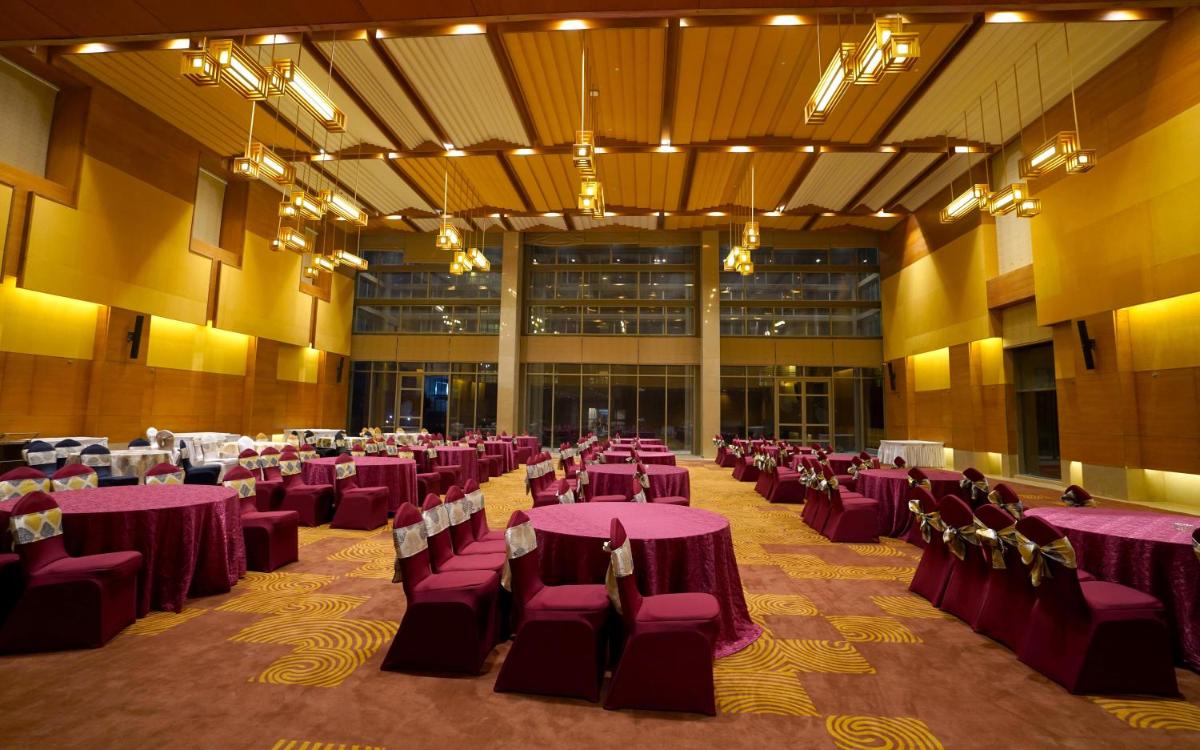 a large room with purple tables and chairs at The Centrum in Lucknow