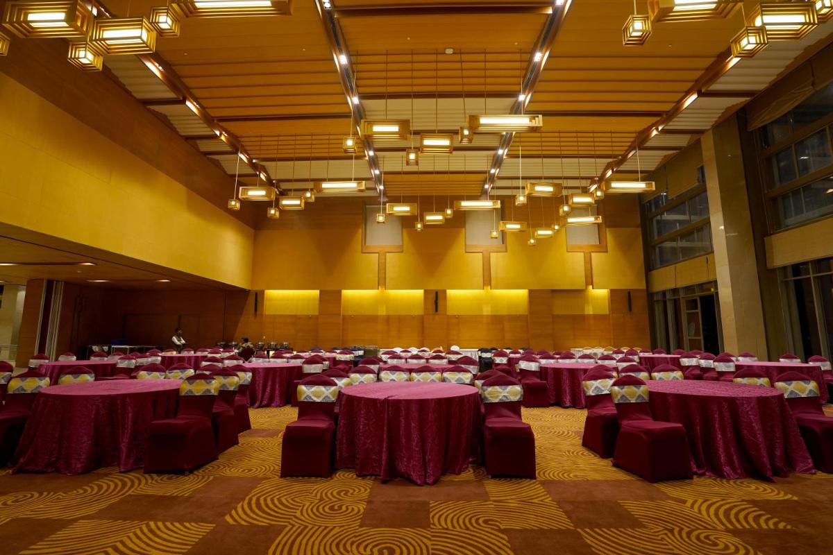 a banquet hall with purple tables and chairs at The Centrum in Lucknow