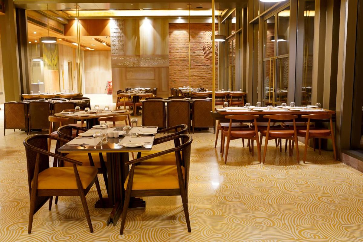 a dining room with tables and chairs in a restaurant at The Centrum in Lucknow