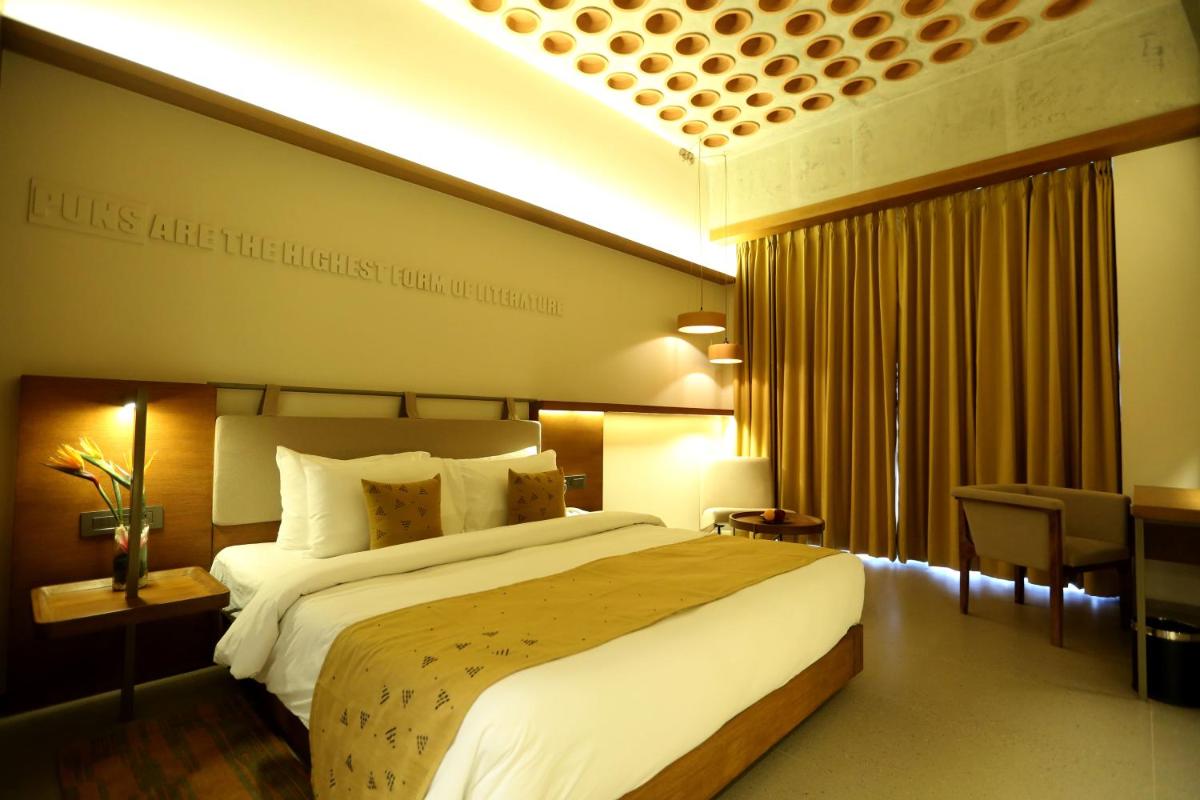 a hotel room with a large bed and a desk at The Centrum in Lucknow