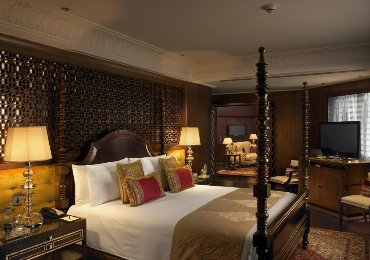 a bedroom with a bed and a television in it at The Leela Palace Udaipur in Udaipur