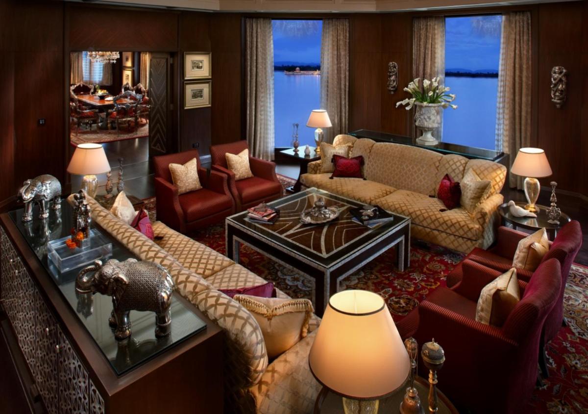 a living room with a couch and a table at The Leela Palace Udaipur in Udaipur
