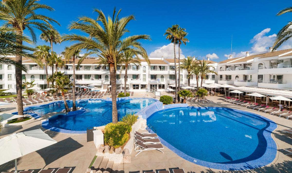 Una vista aérea del complejo con palmeras y una piscina. en Hoposa Hotel & Apartaments VillaConcha, en Puerto Pollensa