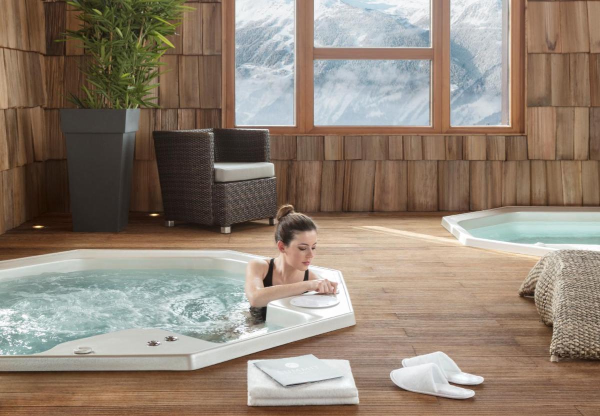 une jeune fille assise dans un bain à remous dans l'établissement ILY Hotels & Spa La Rosiere, à La Rosière