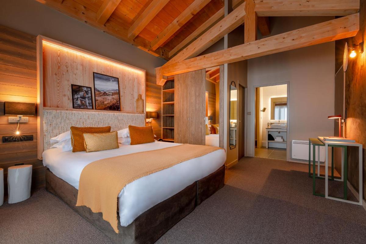 une chambre avec un grand lit dans une pièce dans l'établissement ILY Hotels & Spa La Rosiere, à La Rosière