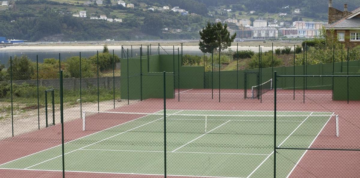una pista de tenis con dos redes de tenis en Hotel Las Sirenas, en Viveiro