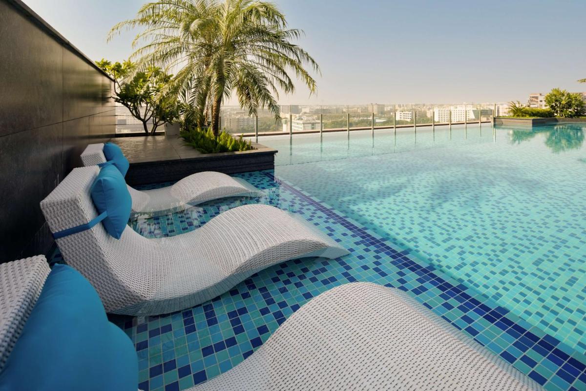 a resort swimming pool with a blue and white resortvisorvisorvisor at Radisson Blu Mumbai International Airport in Mumbai a resort swimming pool with a blue and white resortvisorvisorvisor at Radisson Blu Mumbai International Airport in Mumbai