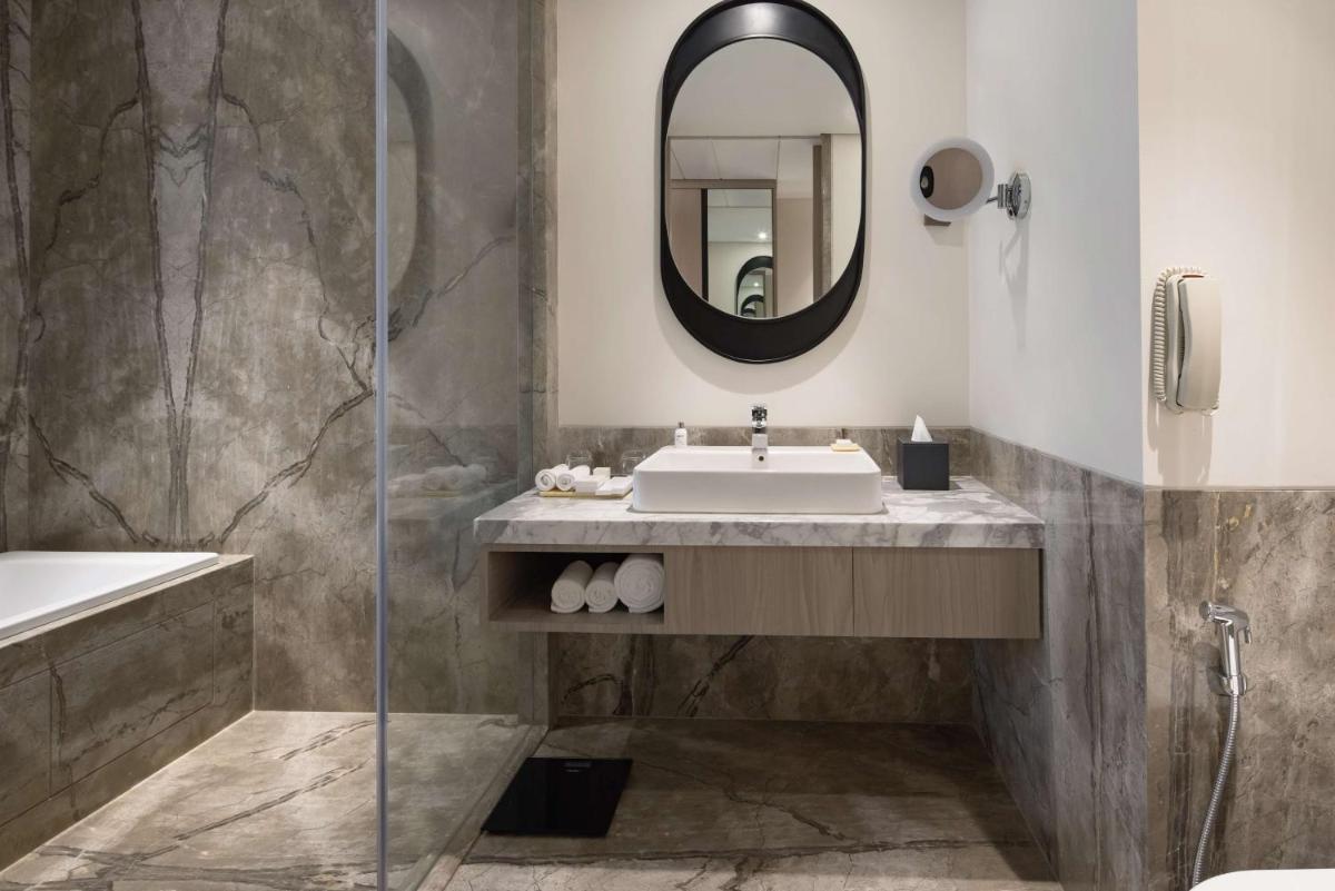 a bathroom with a sink and a mirror at Radisson Blu Mumbai International Airport in Mumbai a bathroom with a sink and a mirror at Radisson Blu Mumbai International Airport in Mumbai