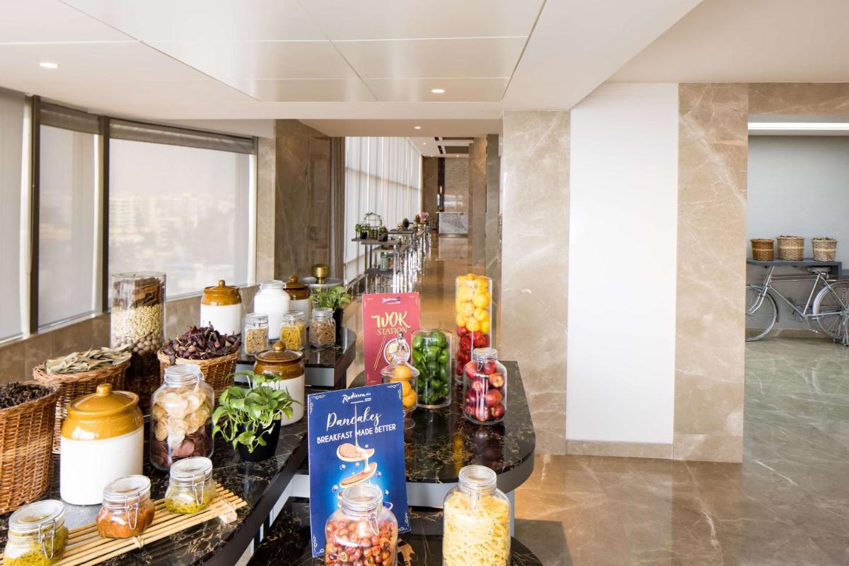a lobby with a table full of food items at Radisson Blu Mumbai International Airport in Mumbai a lobby with a table full of food items at Radisson Blu Mumbai International Airport in Mumbai