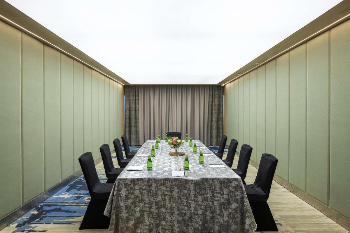 a conference room with a long table and chairs at Radisson Blu Mumbai International Airport in Mumbai a conference room with a long table and chairs at Radisson Blu Mumbai International Airport in Mumbai