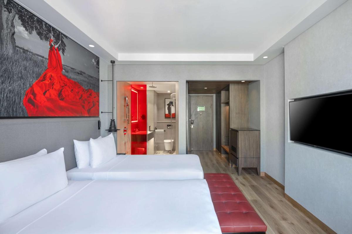 a bedroom with two beds and a flat screen tv at Radisson RED Chandigarh Mohali in Chandīgarh