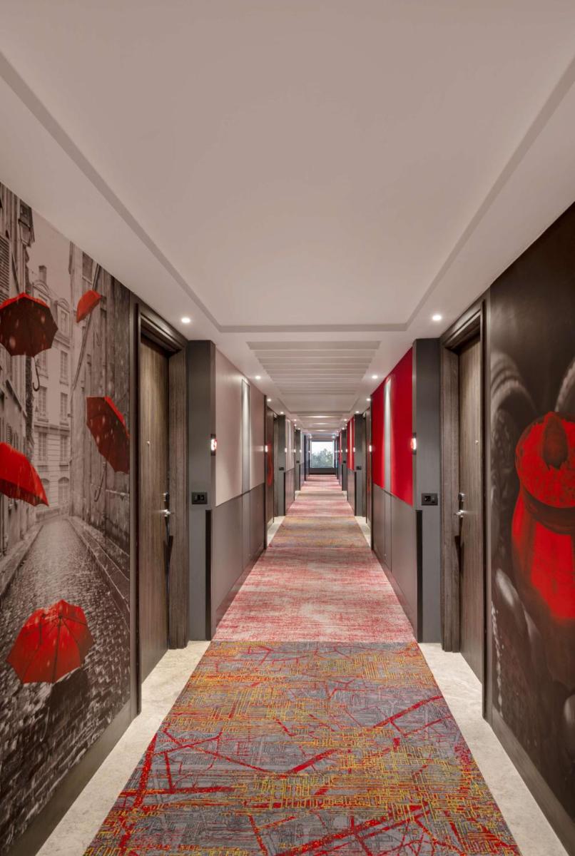 a hallway with a red carpet on the floor and a corridorngthngthngthngth at Radisson RED Chandigarh Mohali in Chandīgarh