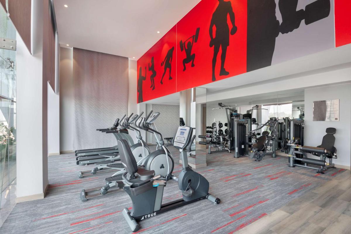 a gym with treadmills and elliptical machines at Radisson RED Chandigarh Mohali in Chandīgarh