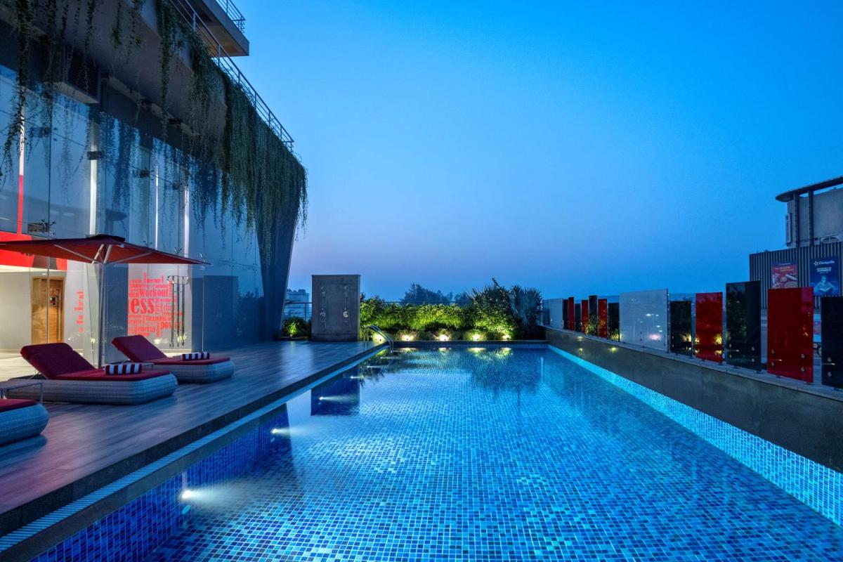 a swimming pool on the side of a building at night at Radisson RED Chandigarh Mohali in Chandīgarh