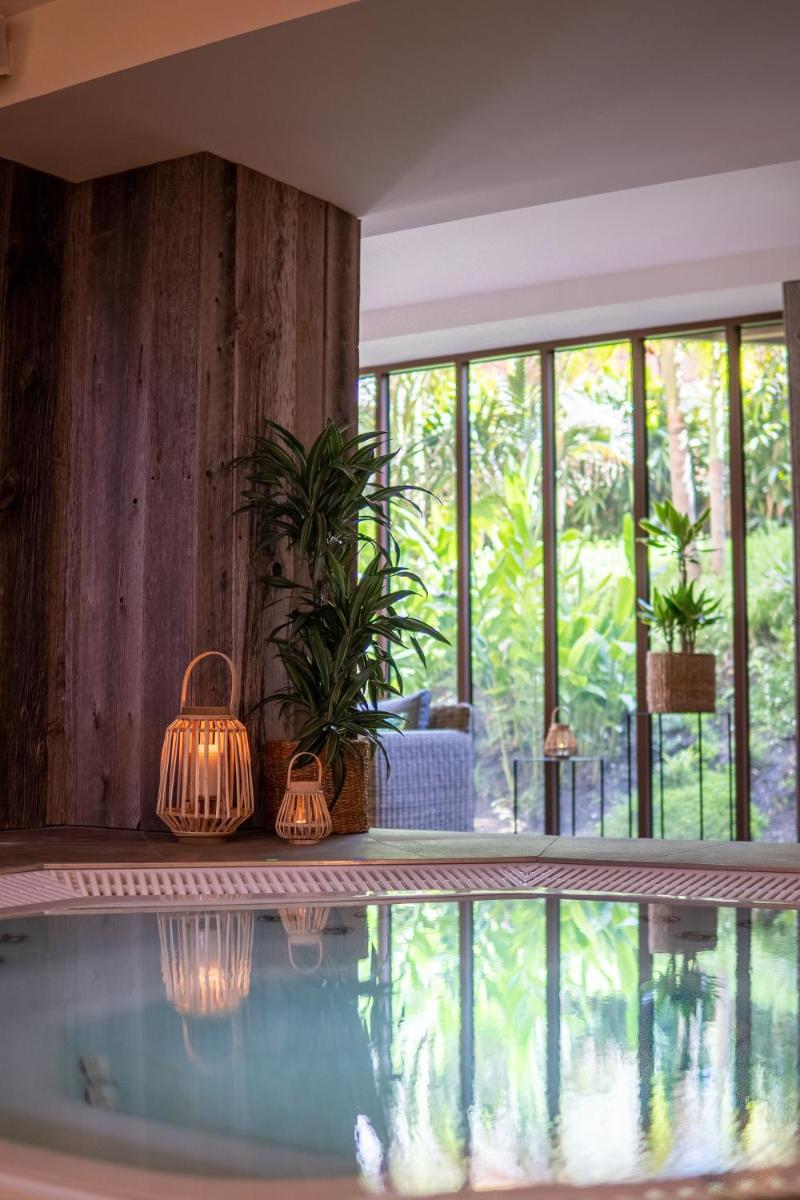 - une piscine avec des lumières et des plantes dans la chambre dans l'établissement Hotel La Zoologie & Spa Bordeaux, à Bordeaux