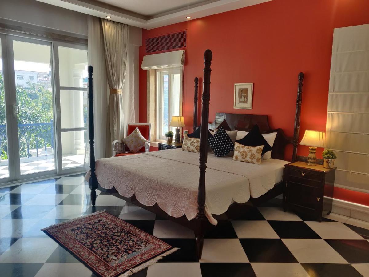 a bedroom with a large bed in a red wall at Dileep Kothi - A Royal Boutique Luxury Suites in Jaipur in Jaipur