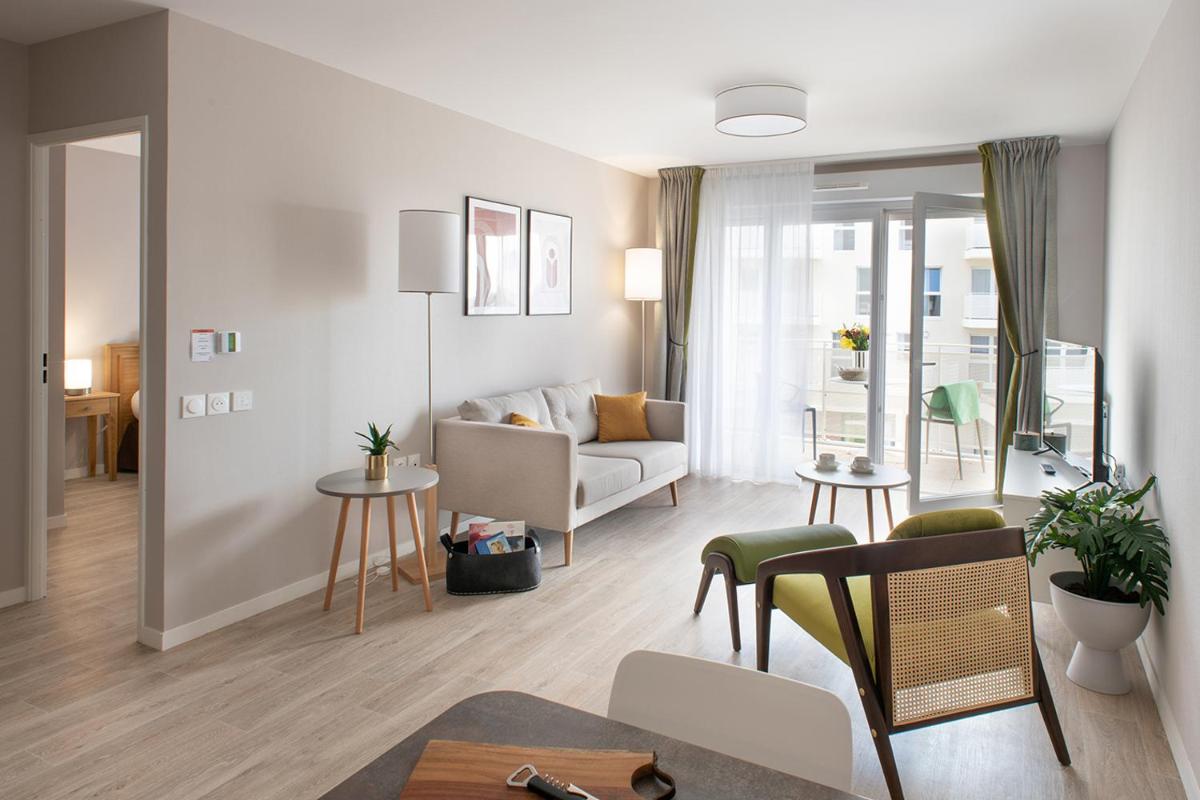 un salon avec un canapé et une table dans l'établissement Le Critérium, à Écouflant