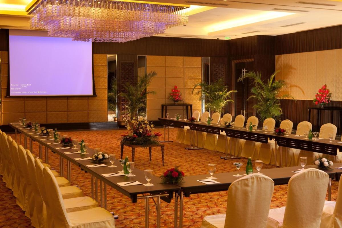 a conference room with a projection screen and tables and chairs at Radisson Blu Hotel, Indore in Indore