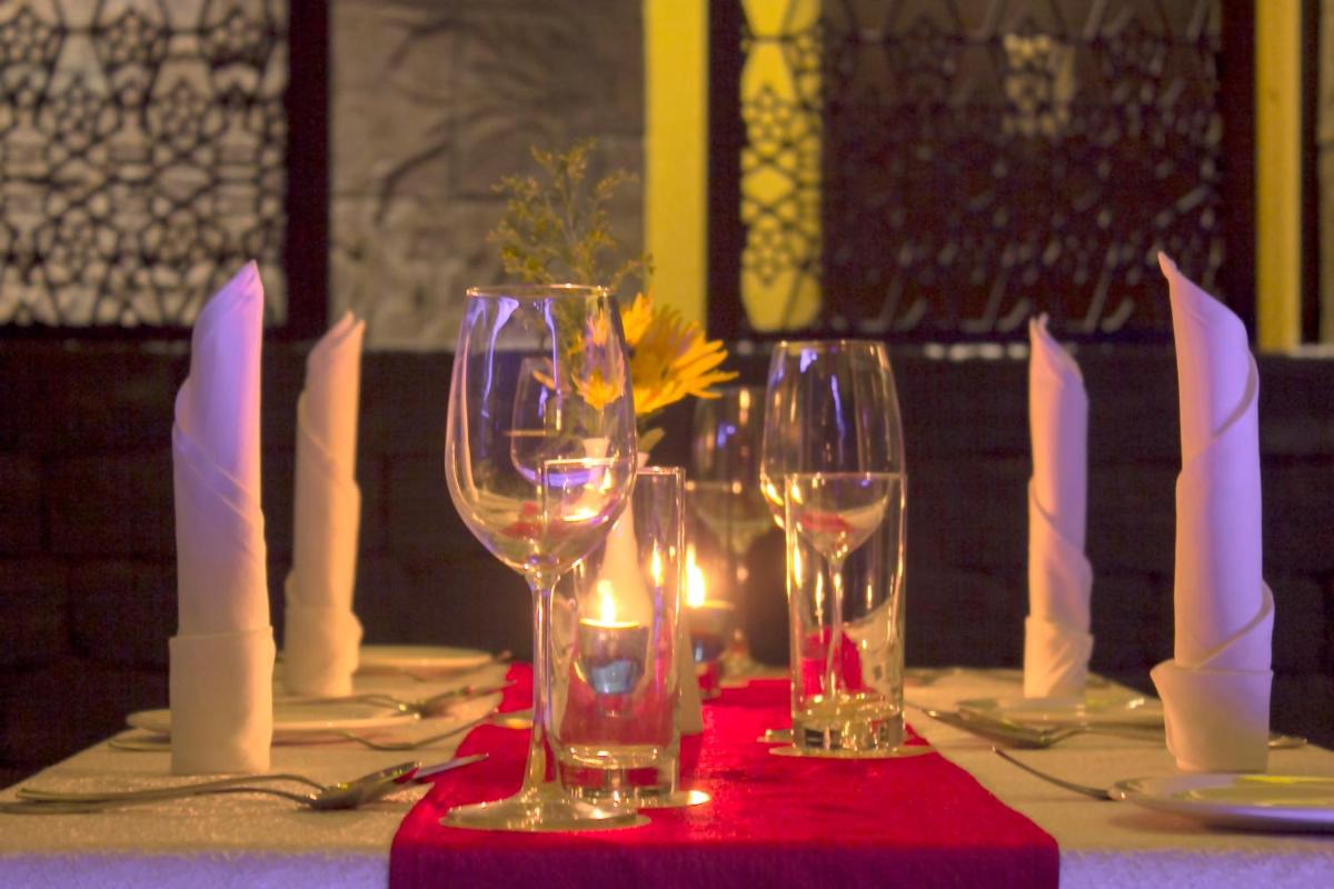 a table with wine glasses on a red table cloth at Sterlings Mac Hotel in Bengaluru