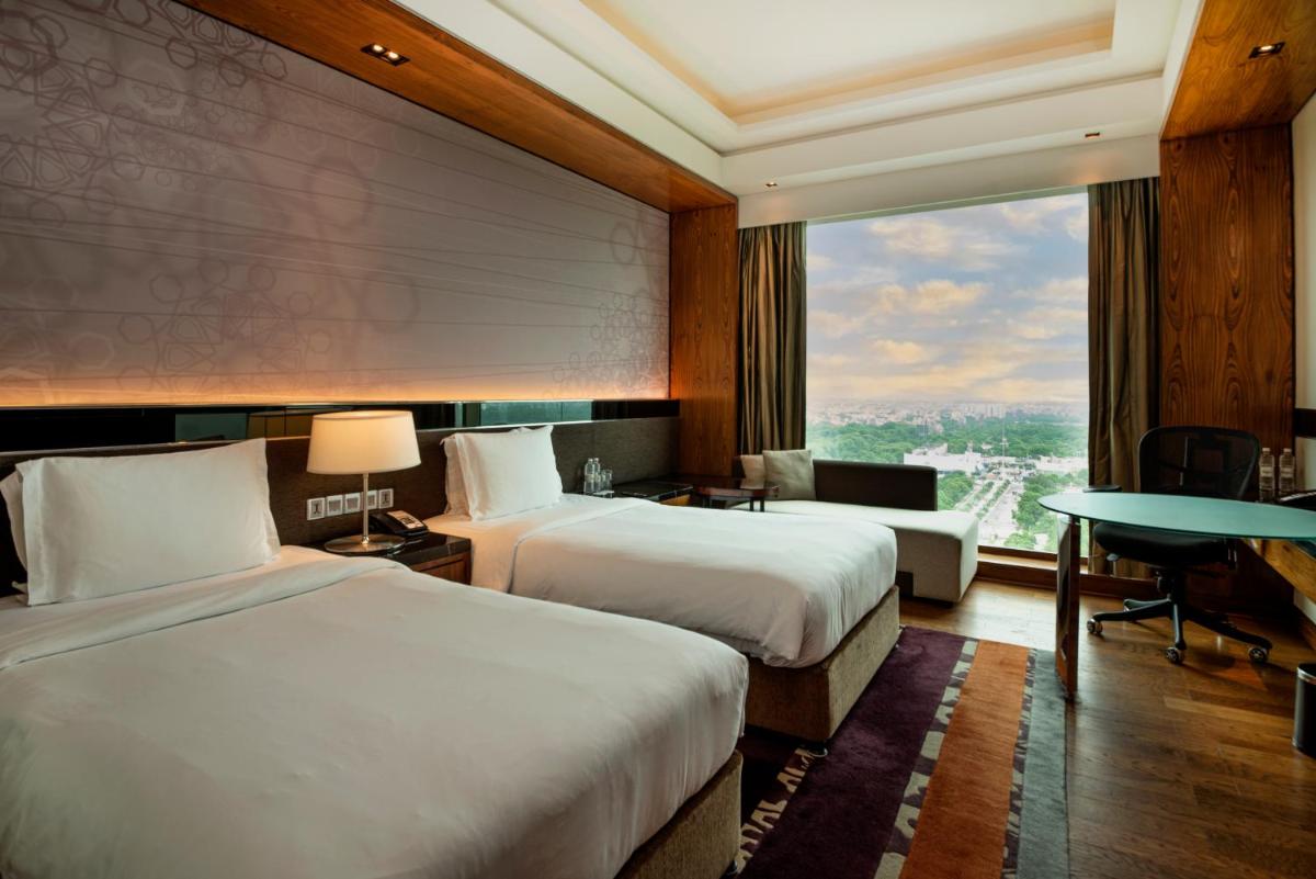 a hotel room with two beds and a large window at Crowne Plaza New Delhi Rohini by IHG in New Delhi a hotel room with two beds and a large window at Crowne Plaza New Delhi Rohini by IHG in New Delhi
