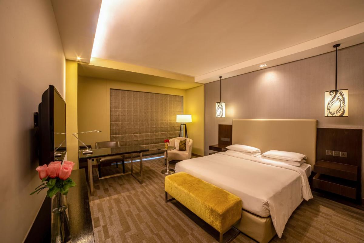 a hotel room with a bed and a desk at Hyatt Regency Ahmedabad in Ahmedabad