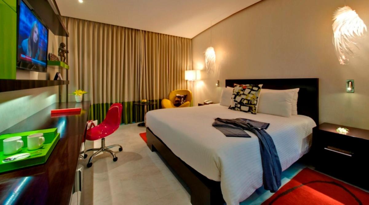 a hotel room with a bed and a flat screen tv at The Park Chennai in Chennai a hotel room with a bed and a flat screen tv at The Park Chennai in Chennai