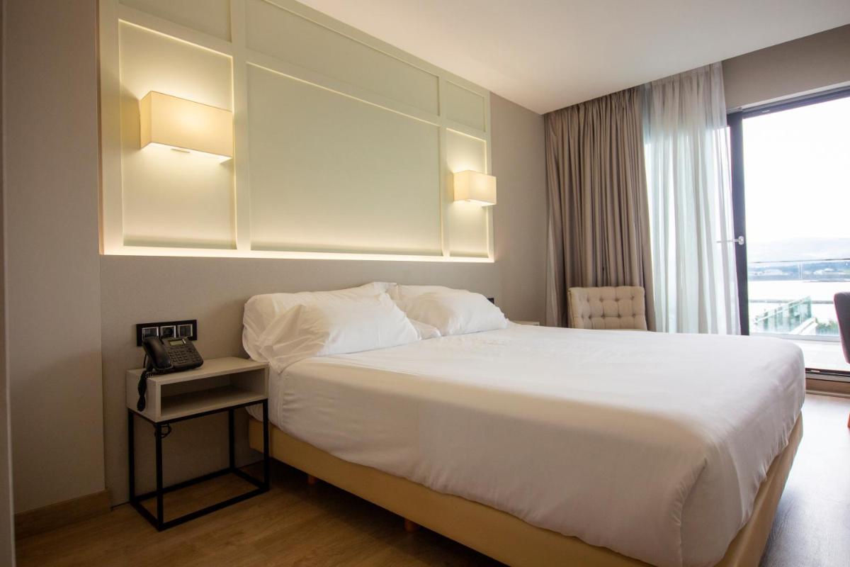 Una habitación de hotel con una cama y una ventana. en Oca Playa de Foz Hotel & Spa, en Foz 41 fotos más