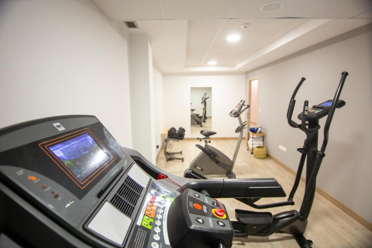 una habitación con un gimnasio con 2 bicicletas estáticas en Oca Playa de Foz Hotel & Spa, en Foz