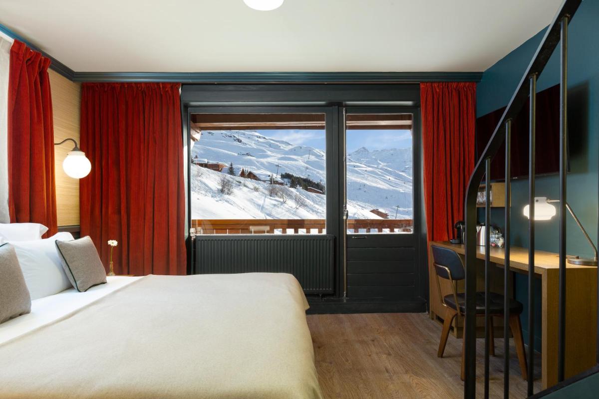 une chambre avec un lit et une vue sur une montagne dans l'établissement Ours Blanc Hotel & Spa, aux Menuires 54 autres photos