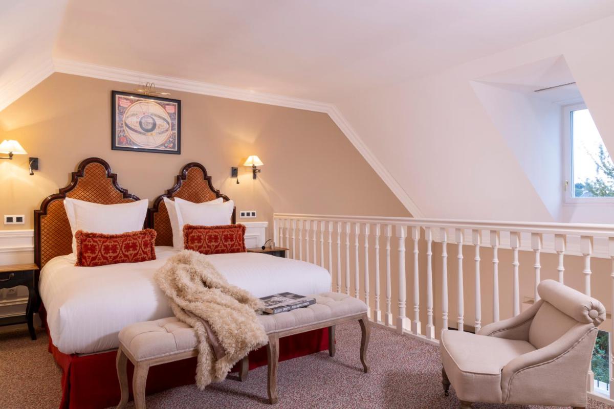 une chambre avec deux lits et une chaise dans l'établissement Ermitage - Mont-Saint-Michel, à Beauvoir