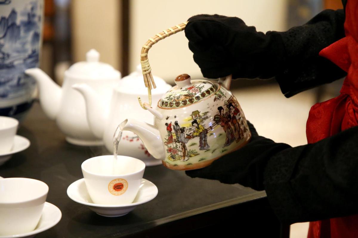 a person is pouring tea into a teapot at Ambassador, New Delhi - IHCL SeleQtions in New Delhi a person is pouring tea into a teapot at Ambassador, New Delhi - IHCL SeleQtions in New Delhi
