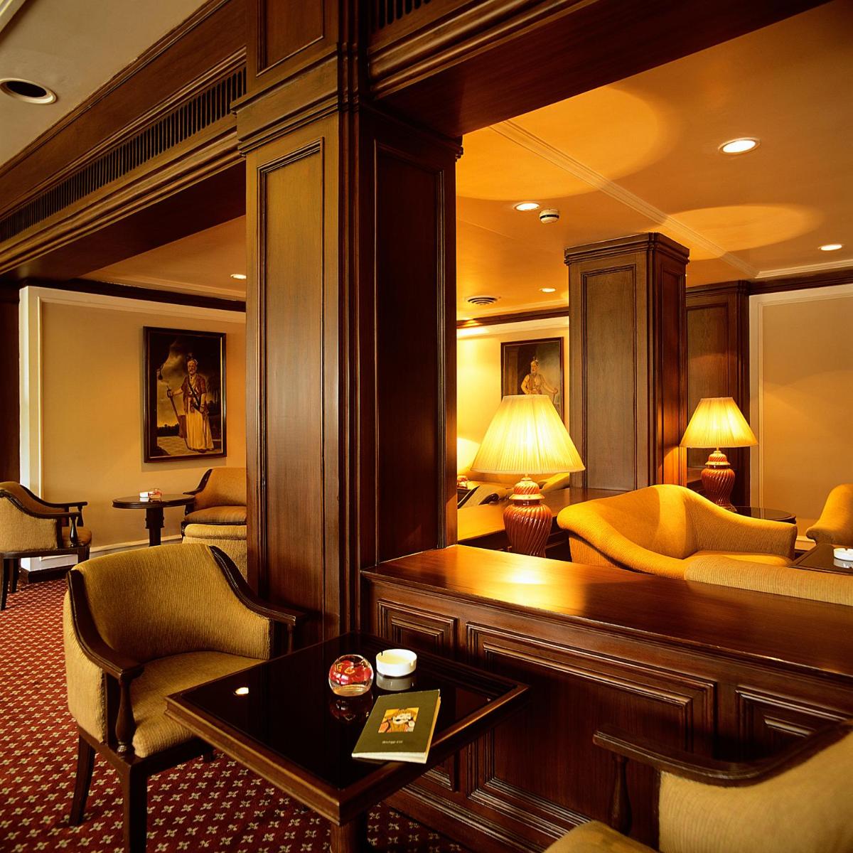 a hotel room with a couch and a table at Trident Chennai in Chennai