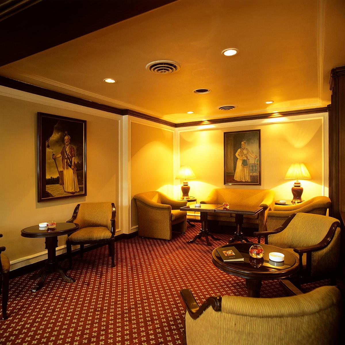 a hotel room with couches and tables and chairs at Trident Chennai in Chennai