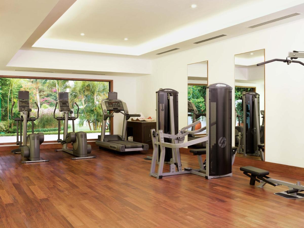 a gym with treadmills and exercise equipment in a room at Trident Chennai in Chennai