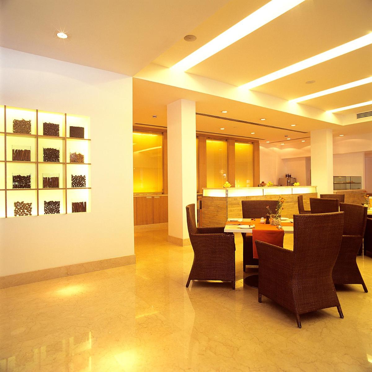 a restaurant with a table and chairs in a room at Trident Chennai in Chennai