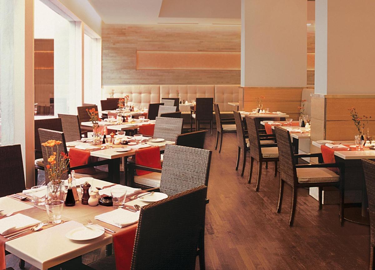 a dining room with tables and chairs in a restaurant at Trident Chennai in Chennai