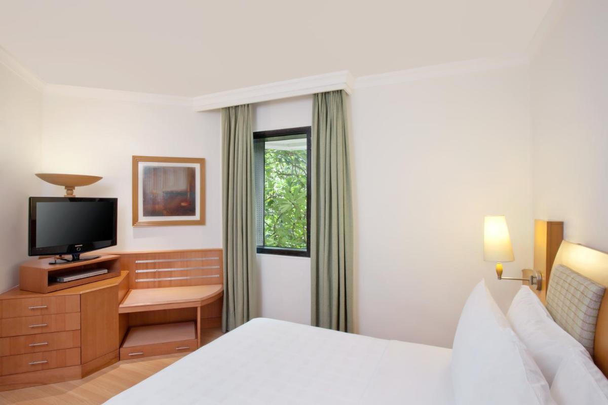 a hotel room with a bed and a television at Trident Chennai in Chennai