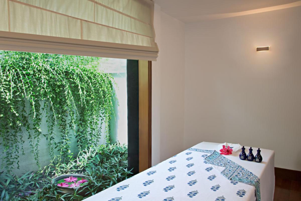 a bedroom with a bed and a window with a plant at Trident Chennai in Chennai