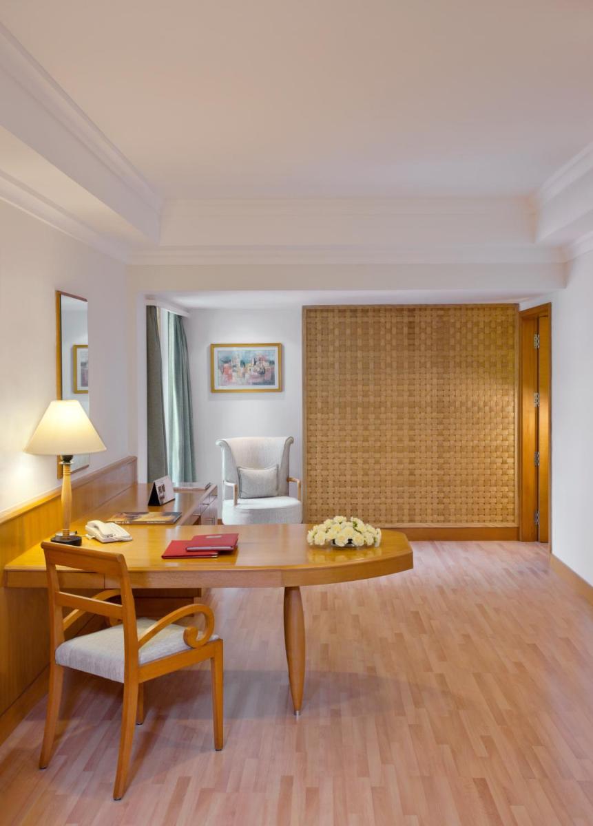 a room with a wooden desk and a chair at Trident Chennai in Chennai