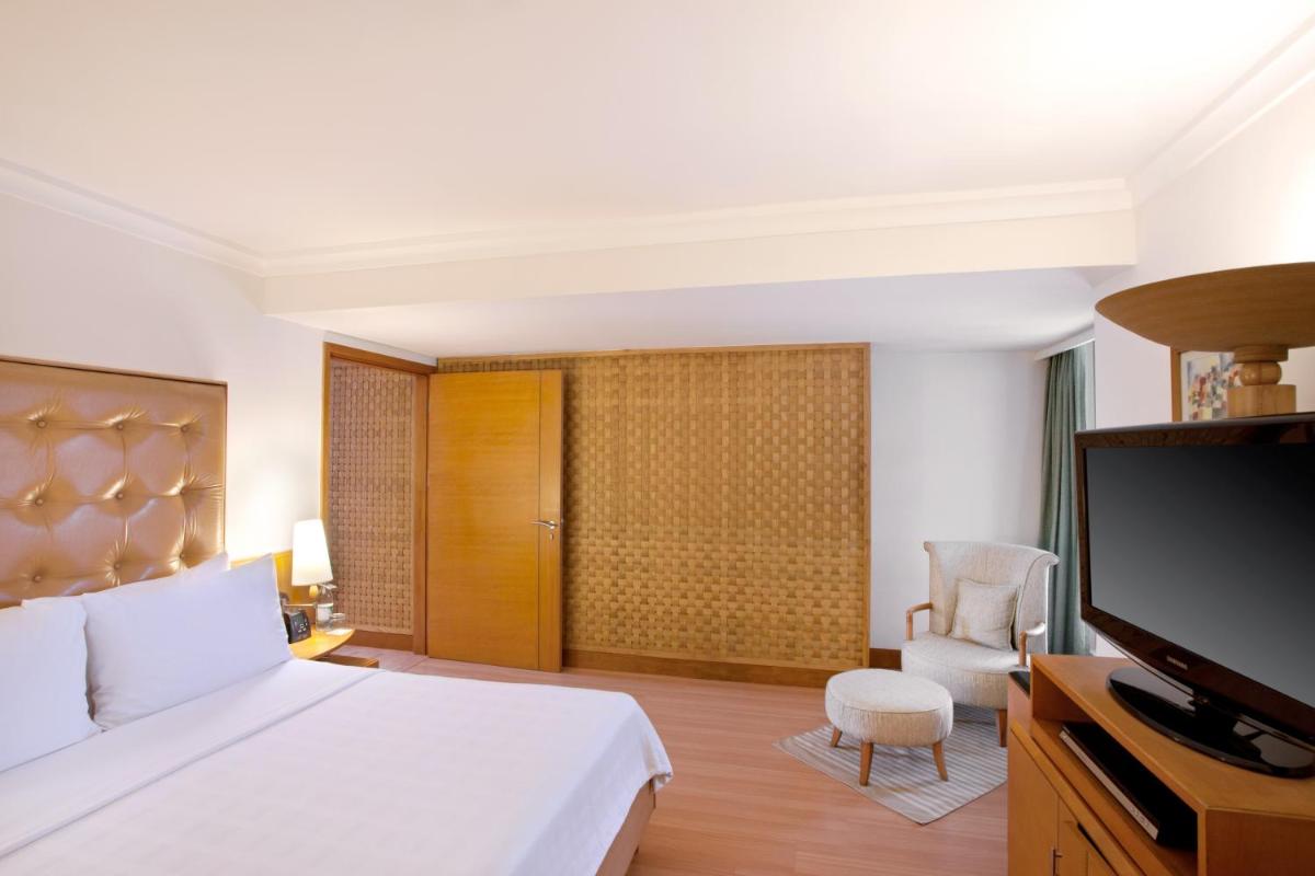 a bedroom with a bed and a flat screen tv at Trident Chennai in Chennai
