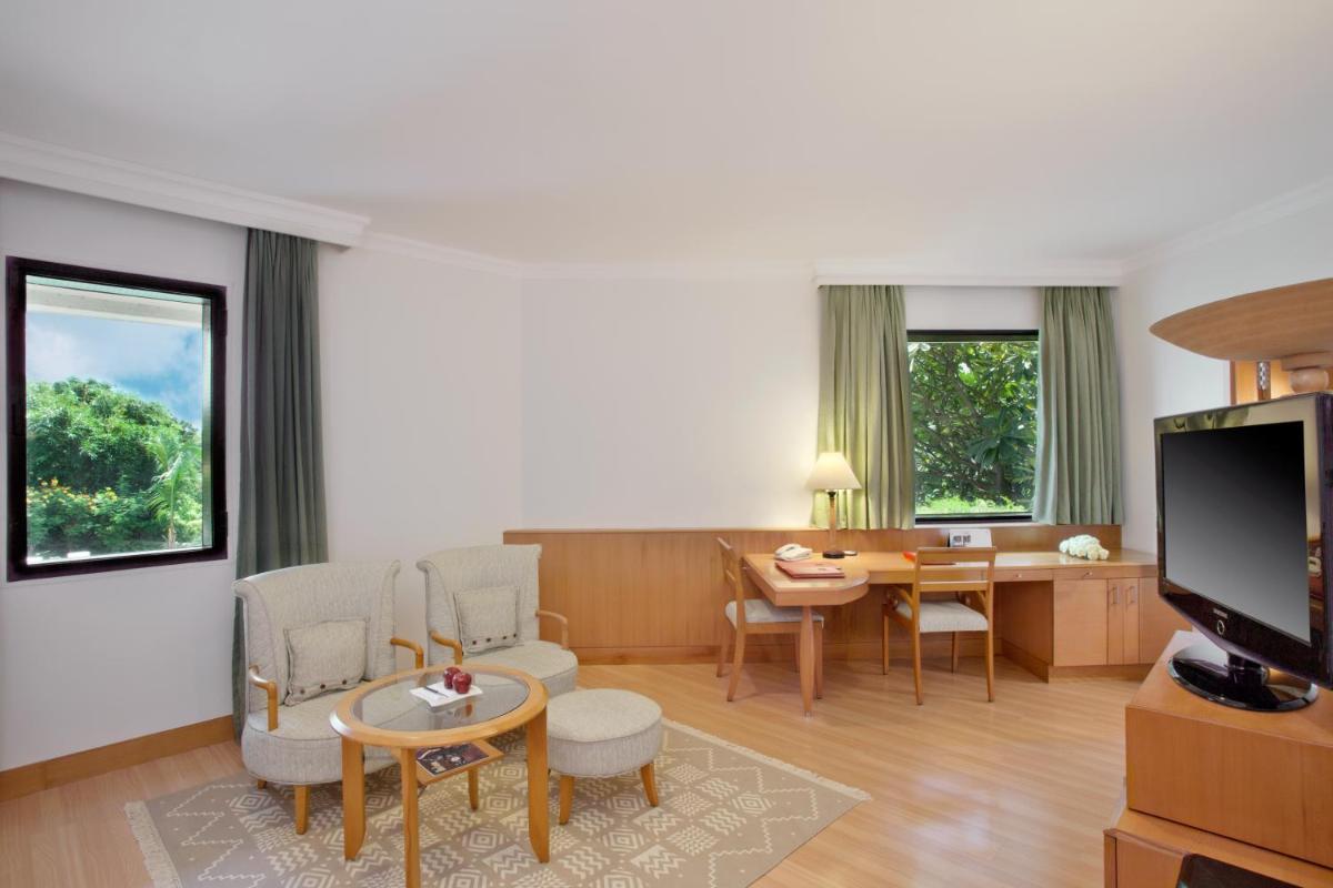 a living room with a desk and a dining room at Trident Chennai in Chennai